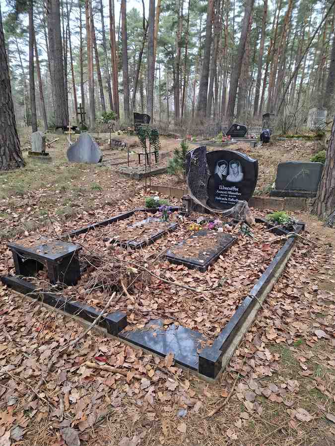Могила с цветами и опавшими листьями в лесу